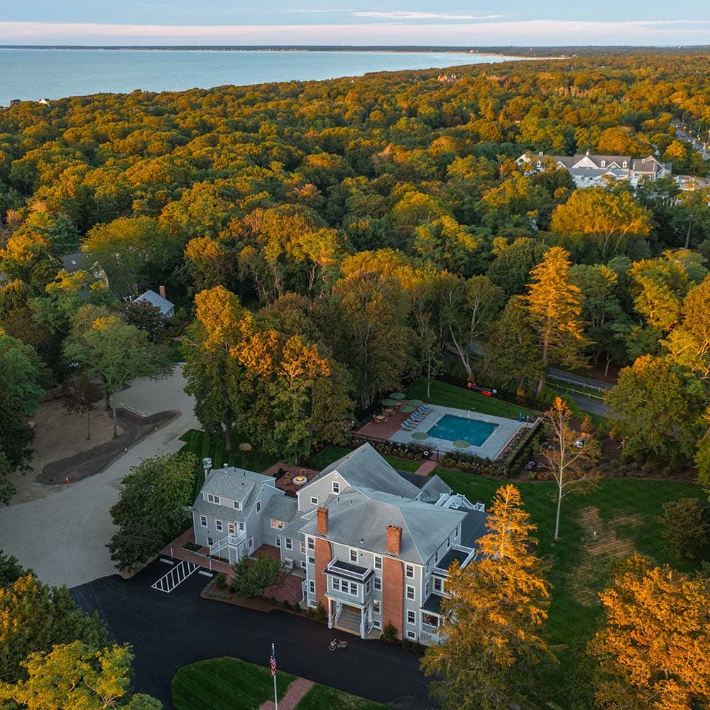 Aerial view of The Charm on Main surrounded by colorful fall foliage in Brewster, Cape Cod