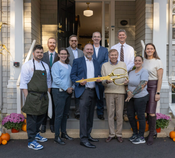 The Corcoran Jennison Hospitality Team at The Charm On Main Ribbon-Cutting Event; A group of ten people standing at the front door of the Inn