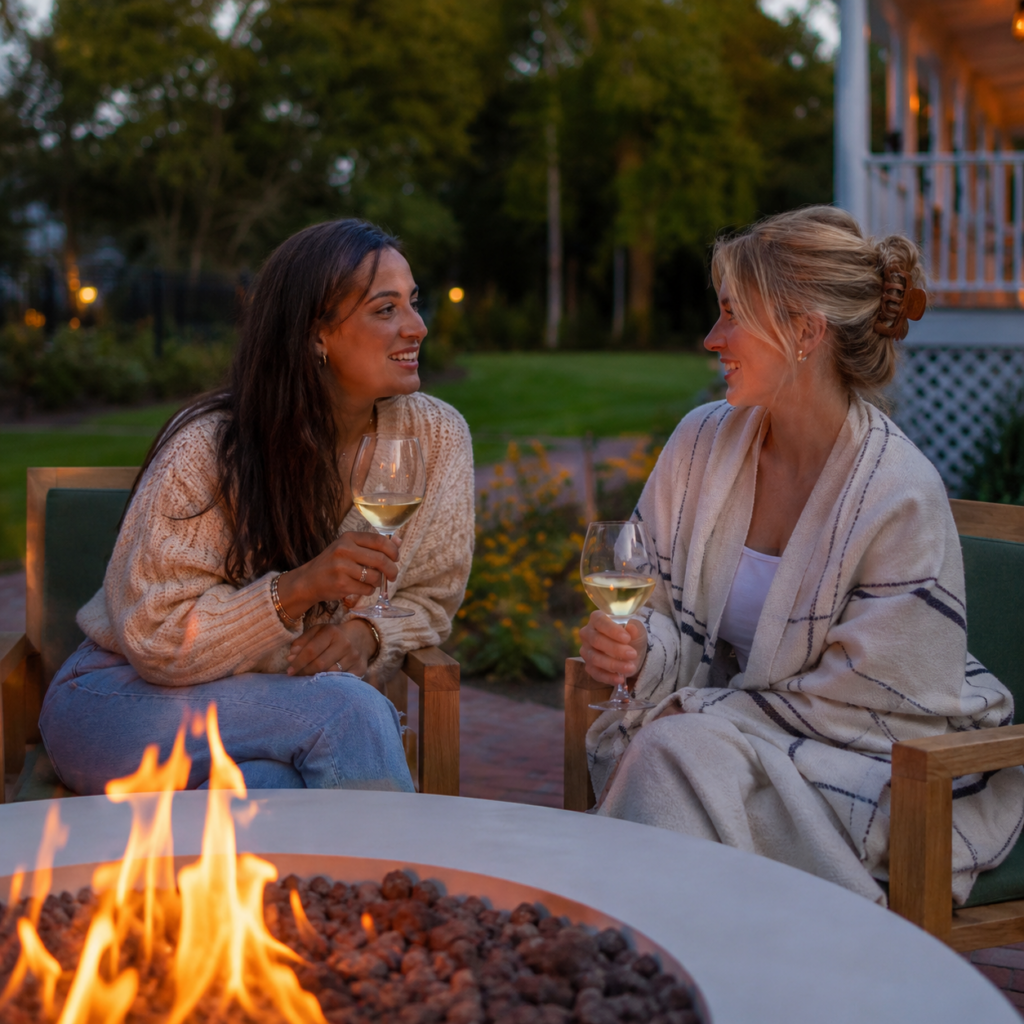 two women sitting by a fire pit